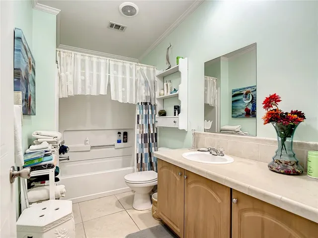 a bathroom with a white bath tub a sink and a large mirror
