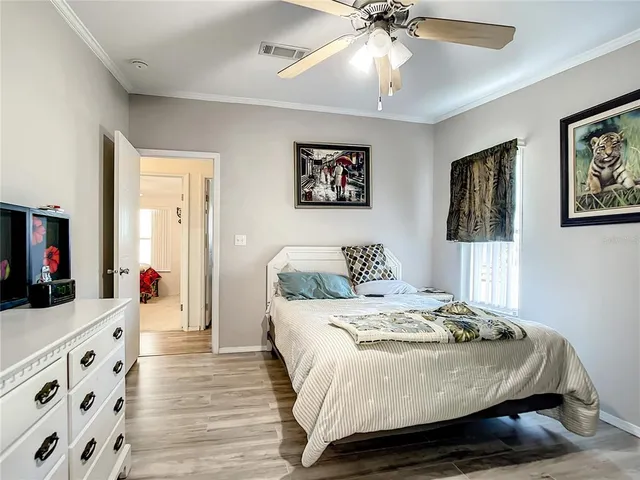 a bedroom with a bed and a flat tv screen on dresser