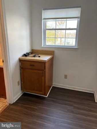 an empty room with wooden floor and window