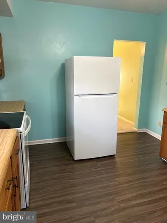a white refrigerator freezer sitting on a wooden floor