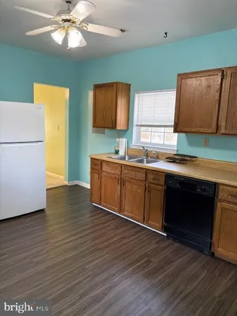 a kitchen with stainless steel appliances a sink cabinets and wooden floor