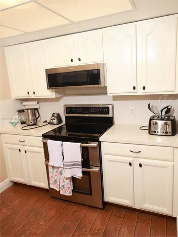 a kitchen with a stove and white cabinets