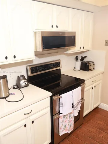 a kitchen with stainless steel appliances a stove a microwave and cabinets