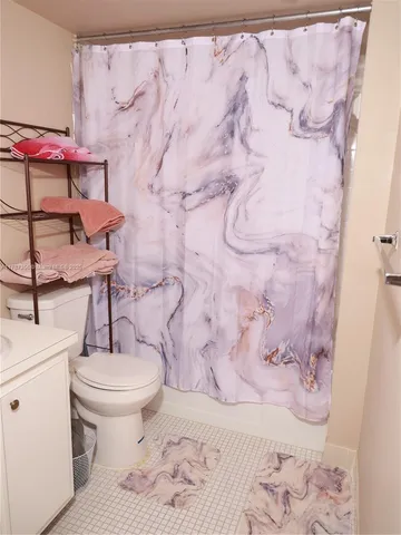 a bathroom with a toilet and a shower curtain
