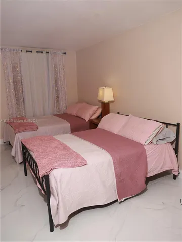 a bedroom with two beds and curtain