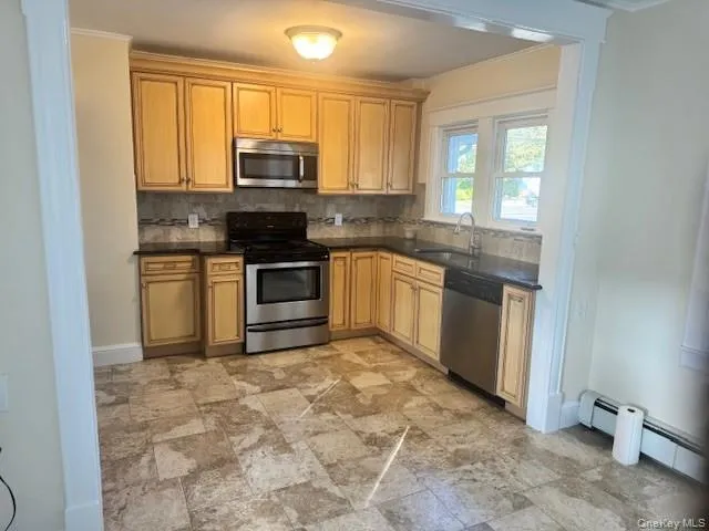 a kitchen with stainless steel appliances granite countertop a stove a sink and a microwave