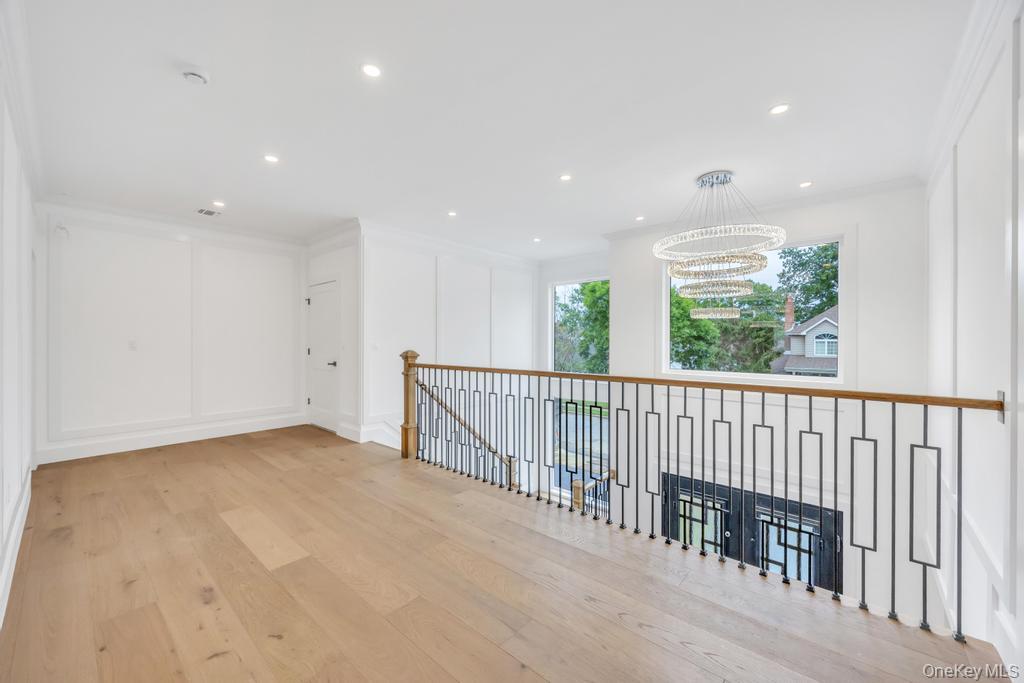 472 Farm Ranch Road East Bethpage, NY 11714 - Photo 19 of 40 Hall with ornamental molding, wood finished floors, recessed lighting, a decorative wall, and an upstairs landing