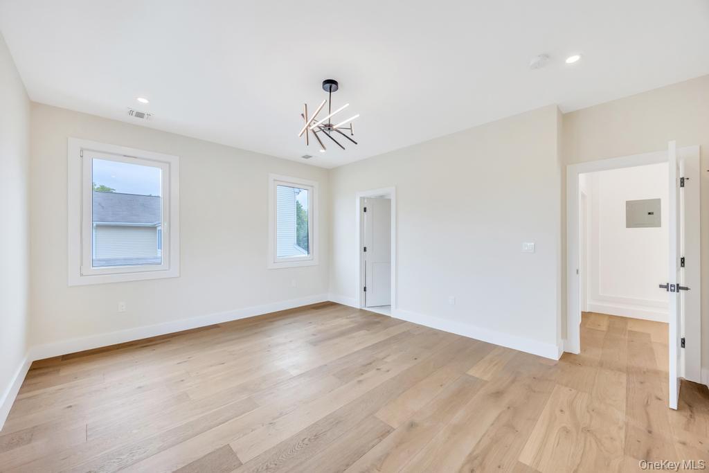 472 Farm Ranch Road East Bethpage, NY 11714 - Photo 24 of 40 a view of an empty room with chandelier fan and wooden floor
