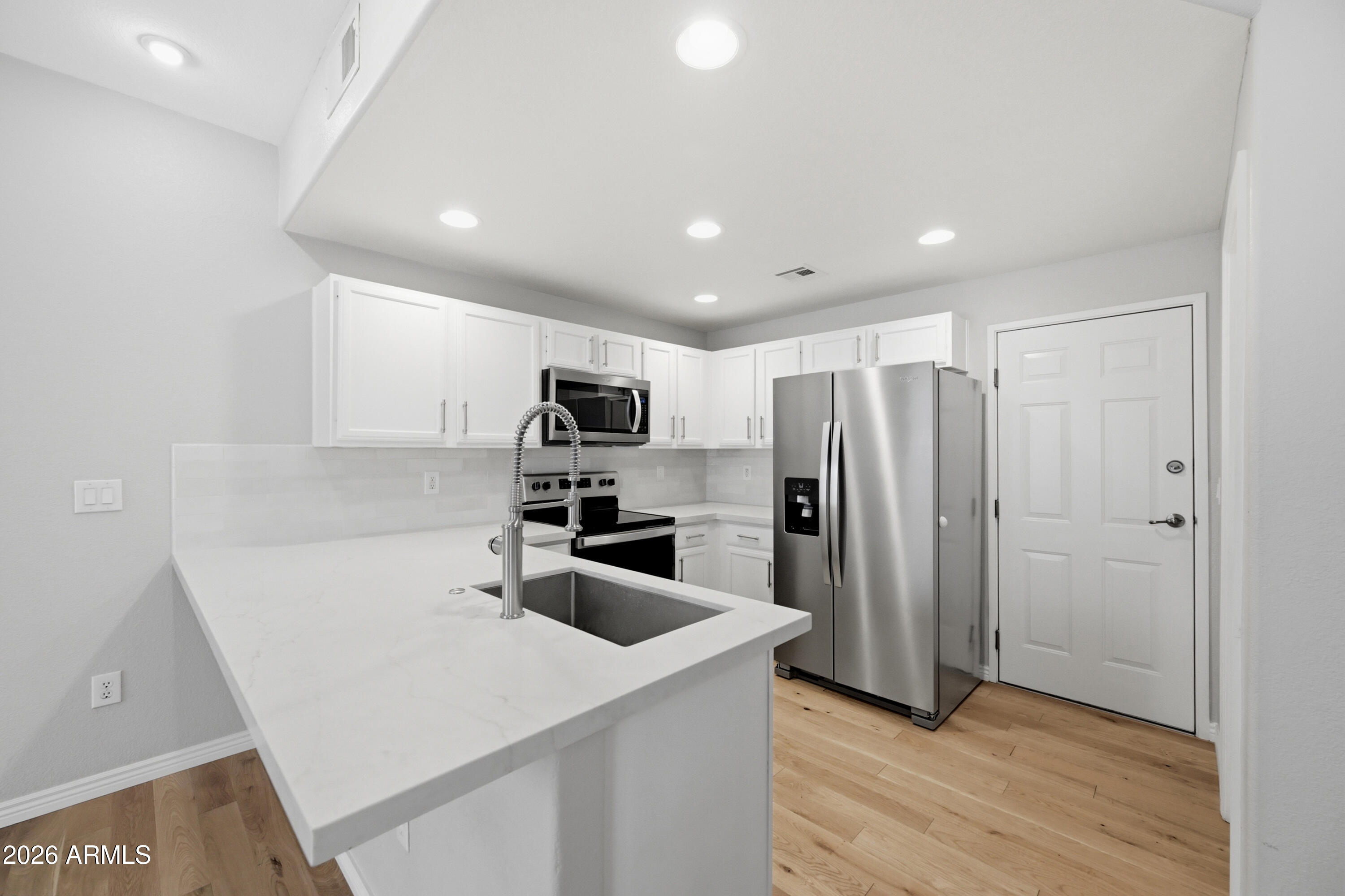 3150 East Beardsley Road, Unit 1009 Phoenix, AZ 85050 - Photo 13 of 31 a kitchen with stainless steel appliances a refrigerator sink and microwave