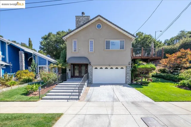 a front view of a house with a yard and potted plants