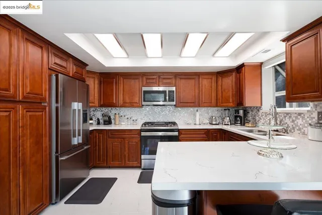 a kitchen with granite countertop a sink stainless steel appliances and cabinets