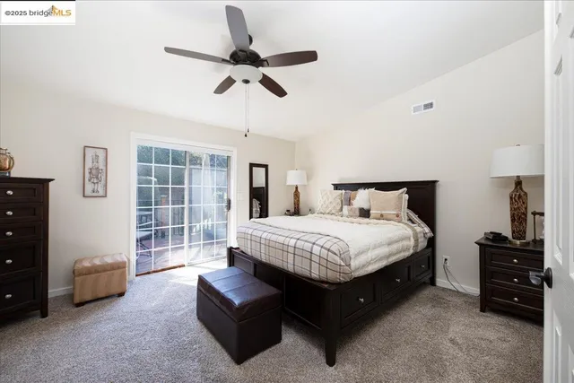 a spacious bedroom with a bed a couch and a chandelier