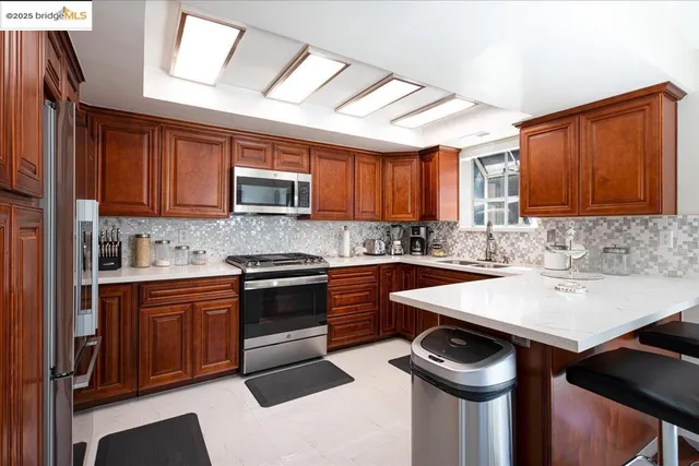 a kitchen with stainless steel appliances granite countertop a sink stove and microwave