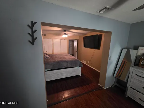 a bedroom with a bed and a flat tv screen on a dresser