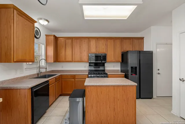 a kitchen with stainless steel appliances granite countertop a refrigerator sink and stove