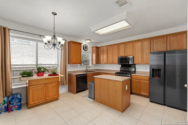a kitchen with stainless steel appliances a stove refrigerator sink and microwave