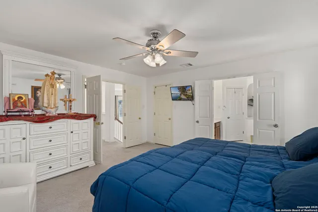 a bedroom with a large bed and a chandelier