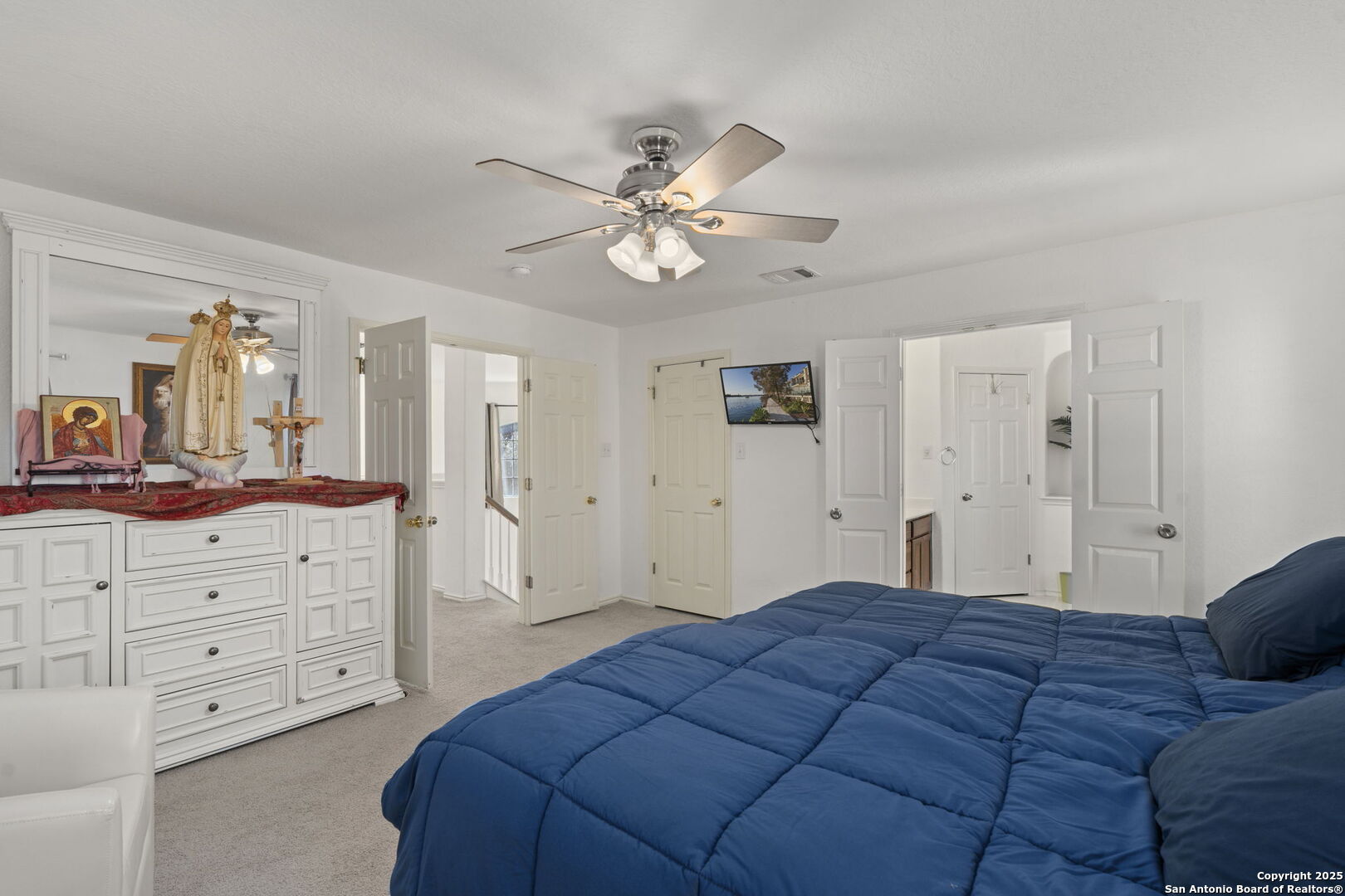 8947 Burnt Path Helotes, TX 78023 - Photo 19 of 34 a bedroom with a large bed and a chandelier