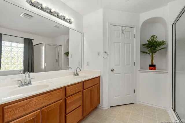 a spacious bathroom with a granite countertop sink a mirror and a shower