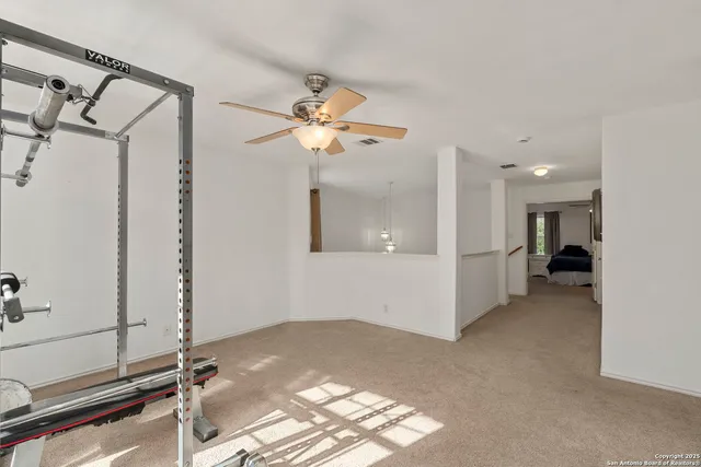 a view of a room with a ceiling fan and window