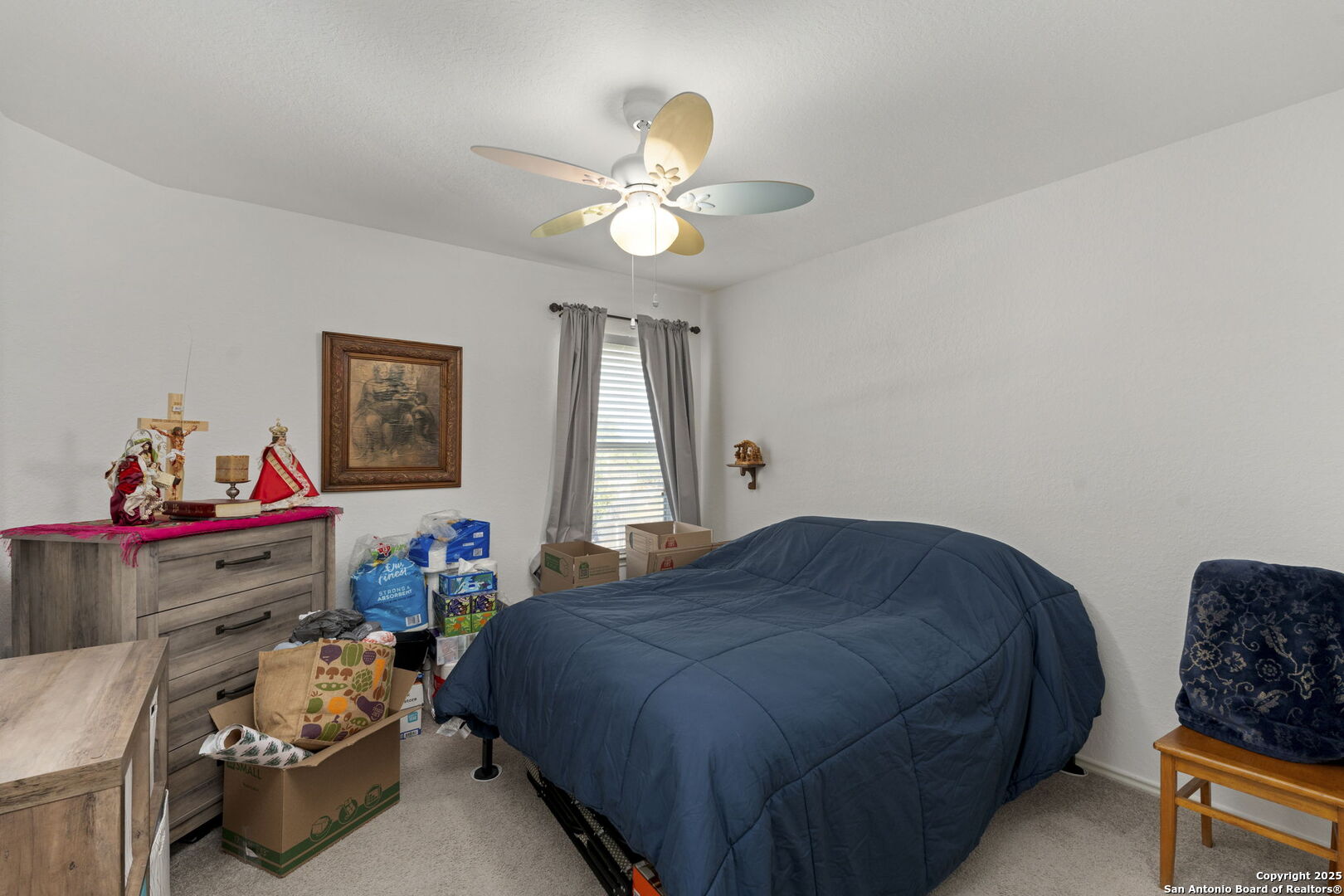 8947 Burnt Path Helotes, TX 78023 - Photo 26 of 34 a bedroom with a bed and a chandelier