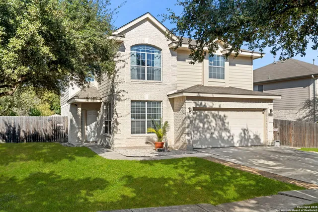 a view of a house with backyard and a tree