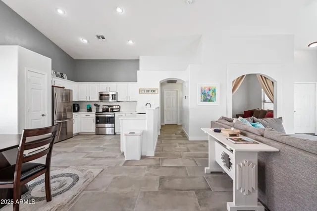 a bedroom with a large bed and a chandelier fan