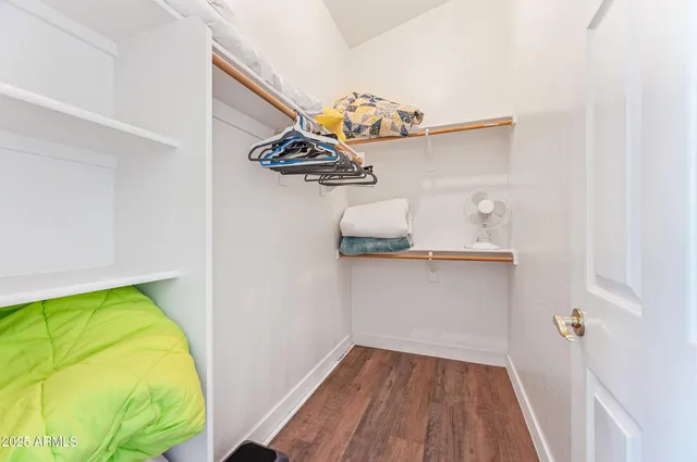a bedroom with a bed and a flat tv screen on dresser