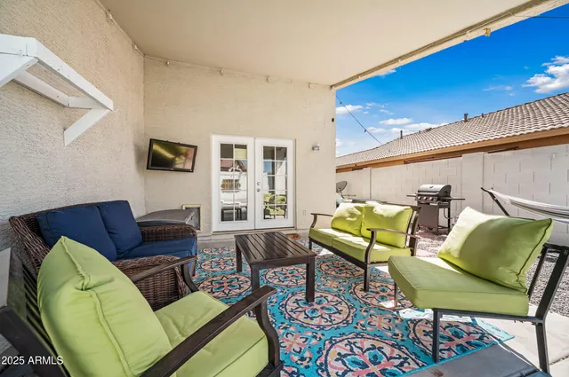 a backyard of a house with table and chairs plants with wooden fence