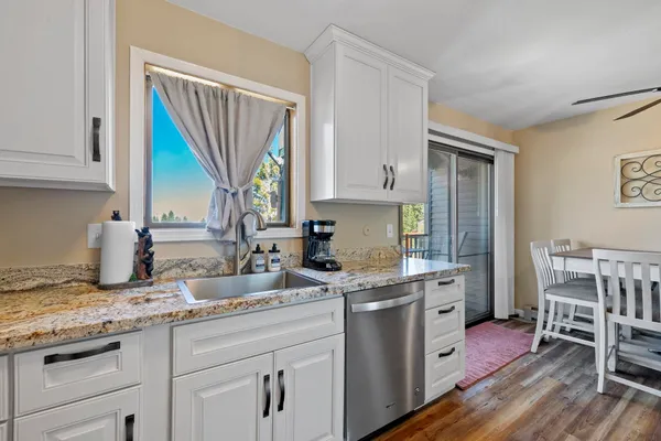 a kitchen with a sink cabinets and wooden floor