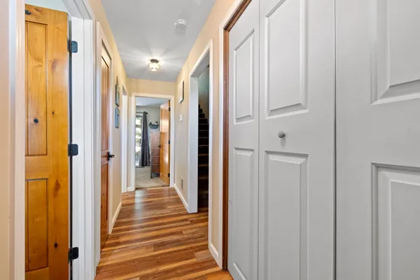 a view of a hallway with wooden floor and staircase