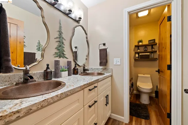 a bathroom with a granite countertop toilet sink and mirror