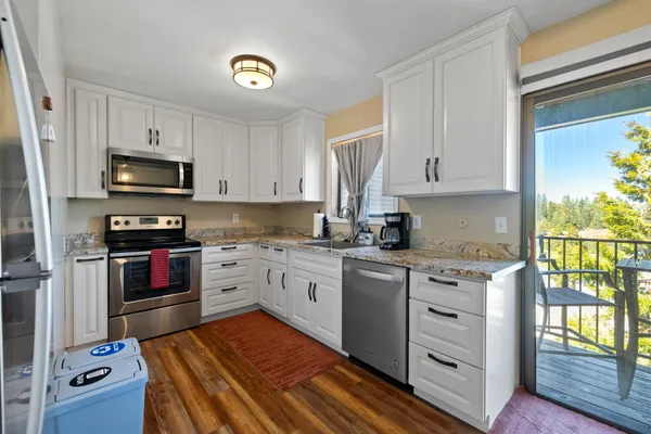 a kitchen with granite countertop a stove top oven microwave and cabinets