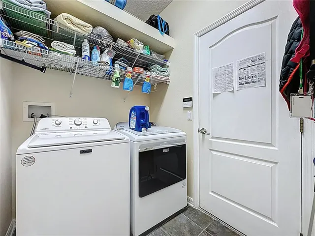 a view of a livingroom with furniture a chandelier and wooden floor
