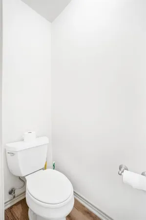 a white toilet sitting next to a white wall