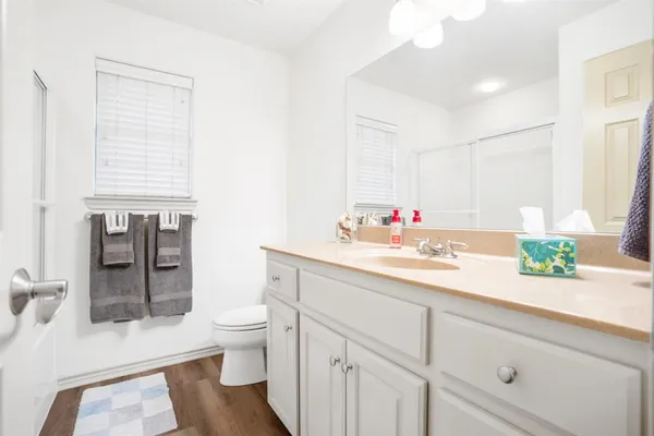 a bathroom with a sink a toilet and a large mirror