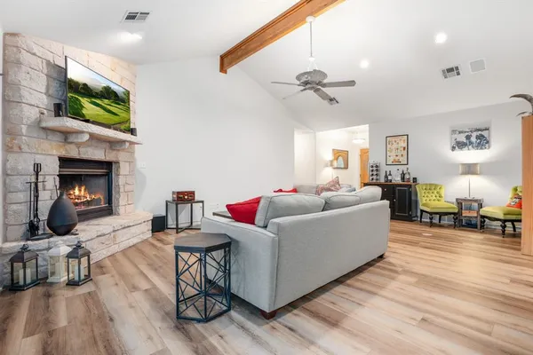 a living room with furniture a fireplace and a flat screen tv