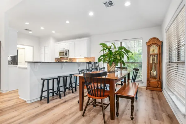 a dining room filled chandelier and wooden floor