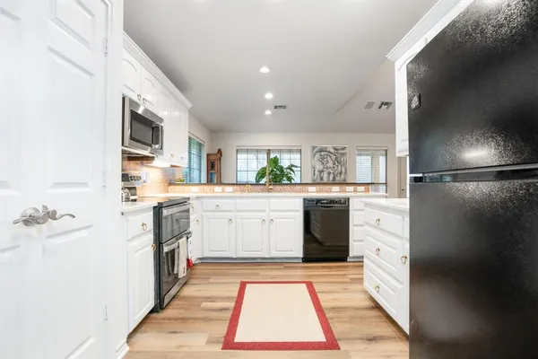 a kitchen with a sink refrigerator and cabinets