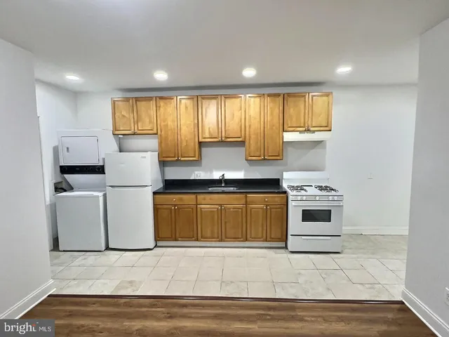 a kitchen with stainless steel appliances granite countertop a stove a sink and a refrigerator