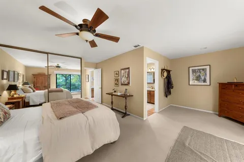 a spacious bedroom with a large bed and a chandelier