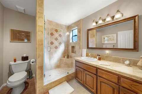 a bathroom with a granite countertop sink mirror vanity and toilet