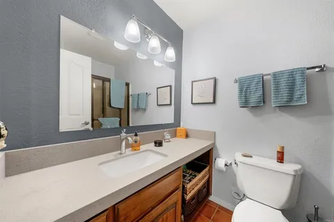 a bathroom with a sink a toilet a mirror and vanity