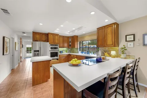 a kitchen with a dining table chairs and refrigerator