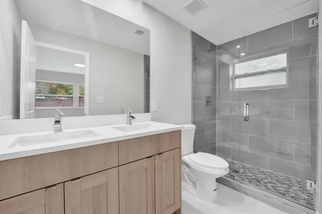 a bathroom with a sink a toilet and shower