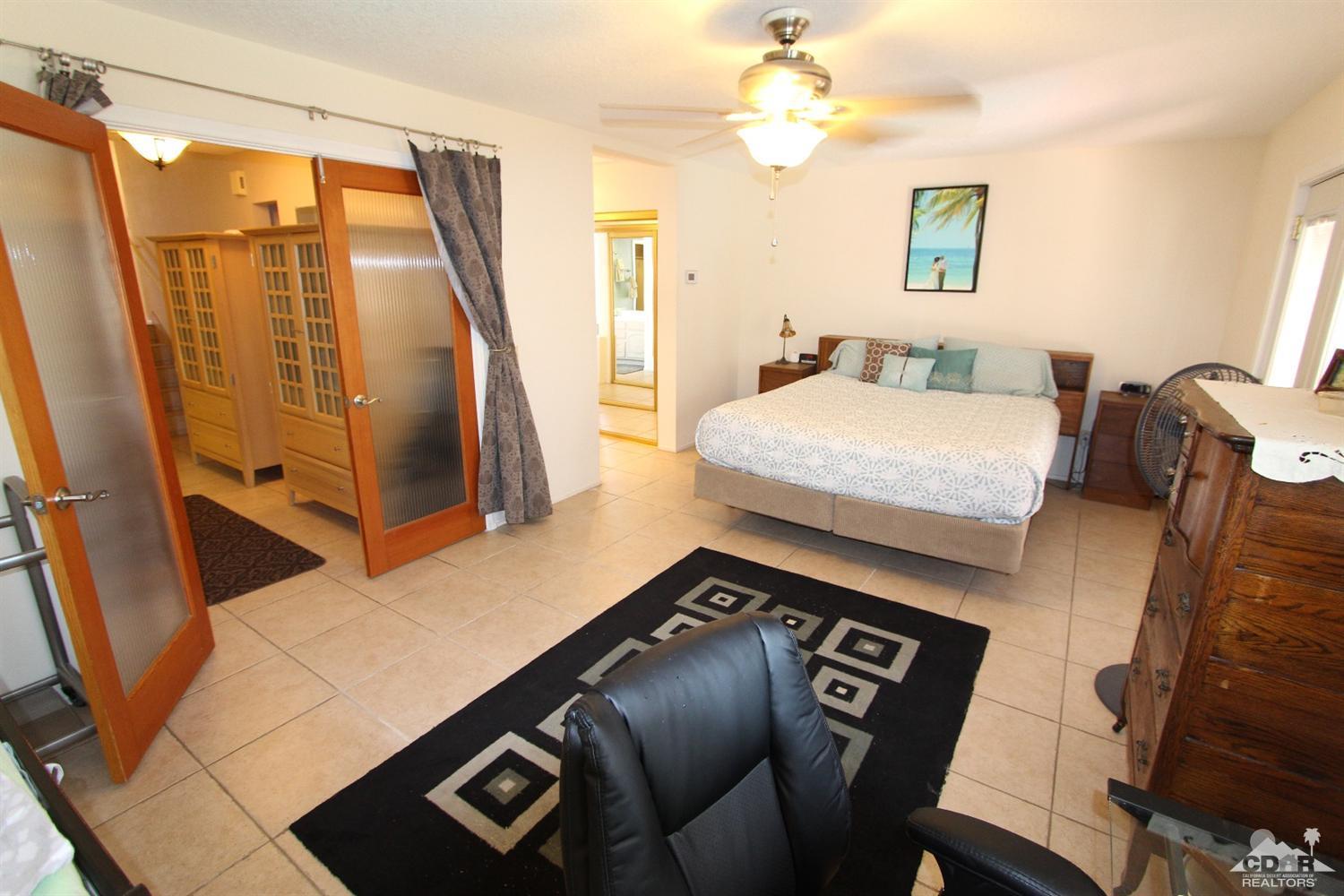 68335 Risueno Road Cathedral City, CA 92234 - Photo 24 of 32 a bedroom with a bed next to a window