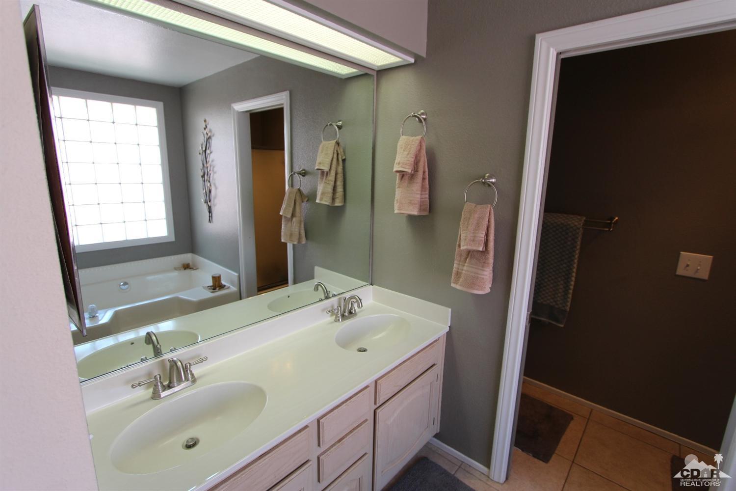 68335 Risueno Road Cathedral City, CA 92234 - Photo 25 of 32 a bathroom with a sink a mirror and a shower