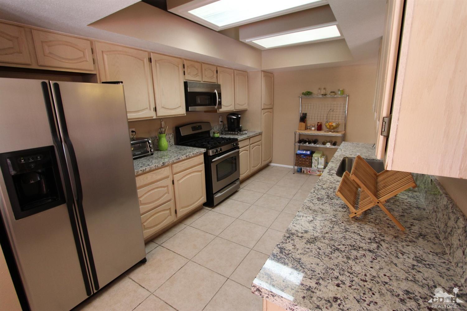 68335 Risueno Road Cathedral City, CA 92234 - Photo 7 of 32 a kitchen with a refrigerator a stove top oven a sink and dishwasher