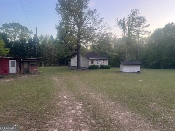 a view of a house with a yard and sitting area