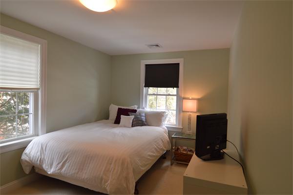115 Booth Street, Unit 115 Needham, MA 02494 - Photo 9 of 15 a bedroom with a bed a flat screen tv and window
